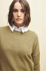 Sweater de punto fino color blanco, con cuello redondo, mangas largas y detalle de calado delicado en la parte superior del pecho, hombros y mangas.