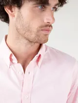 Camisa celeste de corte clásico, con cuello abotonado, manga larga y logo bordado en el pecho.
