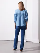Blusa de manga tres cuartos color celeste claro, confeccionada en lyocell, con escote en V y detalle de frunces en el canesú y puños.