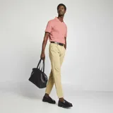 Pantalón chino de corte slim fit, color beige, con cinco bolsillos y cierre de botón y cremallera.