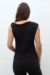 Top sin mangas color bordó, con escote asimétrico drapeado y ajuste al cuerpo.