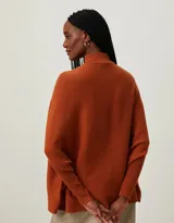 Sweater de punto color naranja, con cuello alto y mangas dolman.