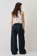 Jeans de denim azul oscuro con corte barrel y diseño amplio en las piernas.