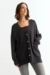 Cardigan de punto color fucsia, con cuello en V, cierre frontal con botones y bolsillos laterales. Presenta un diseño holgado con mangas largas y puños acanalados.