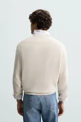 Sweater de punto color beige con textura tipo waffle, cuello redondo y mangas largas con acabado en rib.