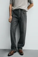 Bota Chelsea de cuero marrón, con punta fina y elásticos laterales oscuros. Posee un tirador trasero y un taco bajo y cuadrado.