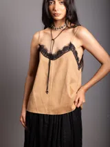 Top de breteles finos estilo camisola, confeccionado en material símil gamuza color negro, con detalle de encaje en el escote y costura vertical frontal.