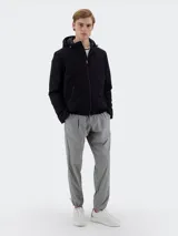 Campera negra con capucha, cierre frontal con cremallera y bolsillos laterales con cierre.