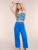 Pantalón capri blanco de corte recto y largo crop, con cintura alta y bolsillos delanteros aplicados estilo parche con detalle festoneado.