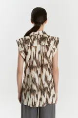Camisa sin mangas de voile de algodón con estampado abstracto en tonos rosados y anaranjados. Tiene cuello camisero, cartera con botones a la vista, tajos laterales y bolsillo de parche en el delantero.