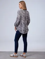 Blusa estampada con cuello a la base, escote en V y abertura con botones. Manga ¾ con puño elastizado.