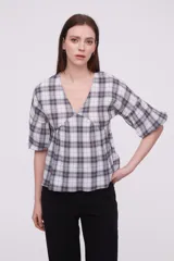 Blusa de algodón con estampado a cuadros, cuello en V, corte holgado y mangas cortas abullonadas con frunces.