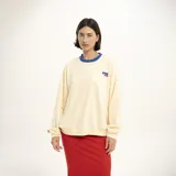 Buzo de algodón color crema, de corte holgado, con cuello redondo ribeteado en azul y logo bordado en el pecho.