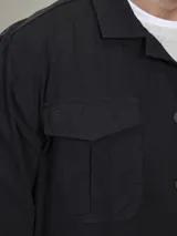 Campera tipo overshirt color azul marino, con cuello clásico, cierre frontal con botones, cuatro bolsillos frontales con solapa y puños abotonados.