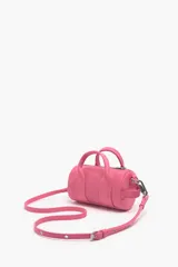 Bolso bandolera de nylon color rosa, con forma cilíndrica, tamaño mini, cierre de cremallera y asa tejida regulable. Exterior personalizado con logo metálico.