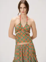 Top halter estampado en tonos rojo y beige, con tirantes finos ajustables al cuello y detalle de cuentas.