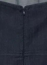 Mono largo de denim oscuro con cuello halter y espalda descubierta. Presenta un diseño de corte recto y holgado con bolsillos laterales y cierre de cremallera en la parte posterior.