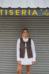 Chaleco de cuero marrón con acabado desgastado, cierre frontal con dos hebillas metálicas y dos bolsillos delanteros con solapa.