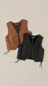 Chaleco de cuero de diseño clásico, con escote en V y detalles de tachas metálicas en los bordes delanteros. Cuenta con cordones laterales ajustables en contraste.