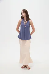 Musculosa de viscosa color rojo, con cuello halter, corte ajustado al cuerpo y detalle de cordones con cuentas en el escote.
