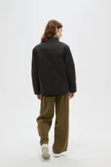 Campera de diseño acolchado con patrón capitoneado, cuello mao y cierre frontal con botones. Presenta mangas largas y un corte recto.