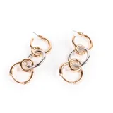 Aros colgantes dorados y plateados con forma de argollas unidas entre sí.