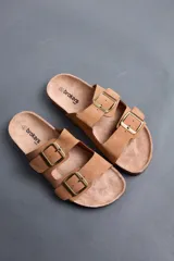 Sandalias Brokers Wear de color beige, con dos tiras ajustables con hebillas metálicas doradas y plantilla anatómica.