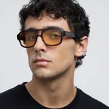 Lentes de sol de aviador oversize con montura marrón y lentes amarillas.