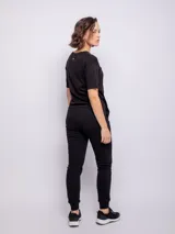 Pantalón tipo babucha de corte deportivo, color beige, con cintura elástica ajustable mediante cordón, puños en los tobillos y bolsillos frontales.