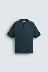 Camiseta de corte regular fit confeccionada en algodón compacto, con cuello en pico y cierre frontal de botones a presión. Presenta mangas tipo raglán.
