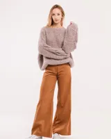 Buzo tejido a mano con lana, color rosa con motas de colores. Diseño oversized, largo entre la cintura y la cadera, con detalle de trenzas en las mangas.