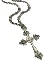 Collar con cadena de eslabones plateada y dije de cruz ornamentada.