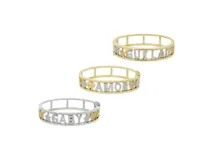 Pulsera rígida dorada con nombre personalizado en letras con incrustaciones de circonitas.