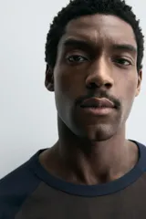 Camiseta de corte relajado con cuello redondo y mangas largas tipo raglán en contraste de color.