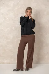 Buzo de punto negro con capucha, cordones ajustables con terminales metálicos, mangas raglán y bolsillo tipo canguro frontal.