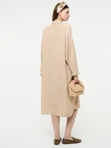 Vestido camisero negro de lino con botones delanteros y bolsillos ocultos.