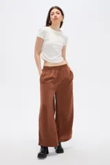 Pantalón ancho de poliéster color marrón, de tiro alto con cintura elástica y bolsillos laterales.