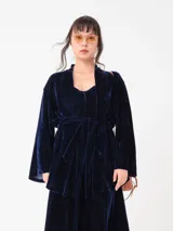 Kimono de terciopelo azul marino con mangas largas amplias, abertura frontal y lazo ajustable en la cintura.