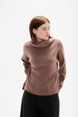 Polera de punto color camel, con cuello alto holgado y mangas largas de diseño amplio.