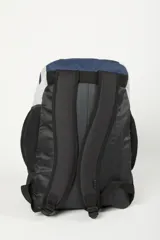 Mochila de color marrón claro y negro, con múltiples bolsillos frontales con cierre y logo de Rusty en negro. Presenta paneles laterales de malla negra y asa superior.