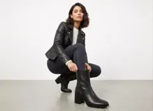 Botas de caña corta confeccionadas en cuero negro con textura granulada, diseño de punta cuadrada y taco bloque de altura media.