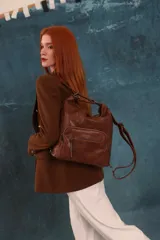 Mochila cartera de símil cuero color marrón, con compartimento principal amplio y bolsillos frontales con cierre. Cuenta con correas ajustables y asa superior para llevar al hombro o como mochila.