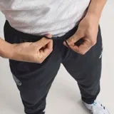 Pantalón deportivo adidas Alemania 1994 de color negro, con cintura elástica con cordón ajustable, bolsillos laterales con cierre y puños elásticos en los tobillos. Presenta detalles de la selección alemana y de la marca.