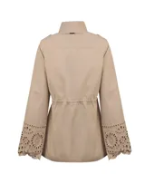 Chaqueta estilo militar beige, confeccionada en algodón orgánico. Cuenta con cuello alto, cierre frontal con cremallera y botones a presión, múltiples bolsillos con solapa en el pecho y la cintura, cordón ajustable en la cintura y detalles de diseño calado en los puños de las mangas largas.