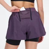 Short de running New Balance Impact Run AT 2 en 1, color morado con short interior negro. Cuenta con tecnología NB DRYx de secado rápido, cintura con cordón de ajuste, bolsillos laterales internos, bolsillo trasero de malla y lazo para llaves.
