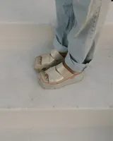 Sandalias con plataforma color dorado, con tiras cruzadas sobre el empeine y suela de goma.