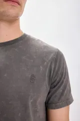 Remera gris de manga corta con efecto lavado y bordado de una mano en el pecho.