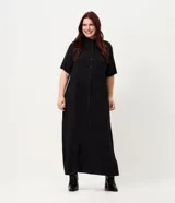 Vestido chemise midi color negro confeccionado en viscosa, de corte recto y holgado. Cuenta con cuello camisero, mangas cortas y cierre frontal con botones al tono.