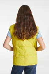 Chaleco puffer amarillo con cuello alto, cierre frontal con cremallera y broches a presión, y bolsillos delanteros con solapa.