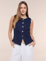 Chaleco de denim azul con silueta entallada, escote redondo cerrado, hilera de botones metálicos frontales y costuras anatómicas.
